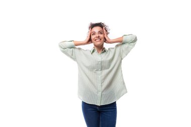 Beyaz arka planda beyaz gömlekli, esmer, kıvırcık bir kadın..