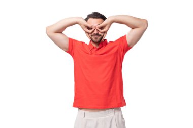 Stüdyonun arka planında, sakallı, kırmızı tişörtlü esmer, komik, esmer bir adam..