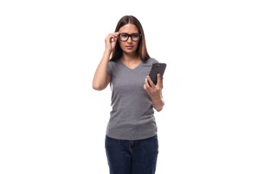 Gri tişörtlü genç, pozitif esmer kadın beyaz arka planda fotokopi alanı olan bir akıllı telefon üzerinde çalışıyor..