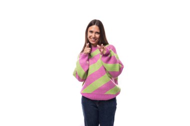 35 yaşında, pembe stil bir kazak giymiş, elini kameraya doğrultmuş, bakımlı bir kadın portresi..