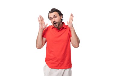 Genç, beyaz, esmer, bakımlı sakallı adam düşünceli bir şekilde duruyor..