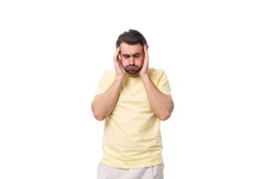 Siyah sakallı ve bıyıklı genç bir adam tişört giymiş bir iş stratejisi geliştirmeyi düşünüyor..