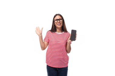 pretty 35 year old european lady in a red striped t-shirt and glasses demonstrates the screen of a vertical smartphone.