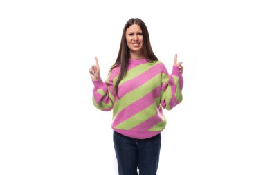 Pembe çizgili bluz giyen şık ve neşeli esmer kadın, beyaz arka planda fotokopi alanı olan bir yerde reklam yapmak için parmaklarını işaret ediyor..