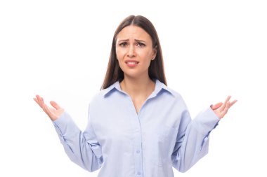 Gökyüzü mavisi gömlekli, esmer, çekici bir kadın ellerini fotokopi arkaplanlı beyaz bir arka plana atıyor..