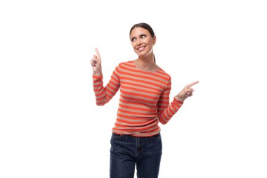 Dar turuncu süveter giymiş ince, genç bir esmer kadın parmaklarını boş bir yeri işaret ediyor..