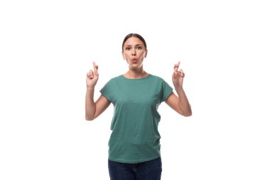 Genç, karizmatik, siyah saçlı, normal tişört ve kot pantolon giymiş bir kadın beklentisiyle parmaklarını çapraz yaptı..