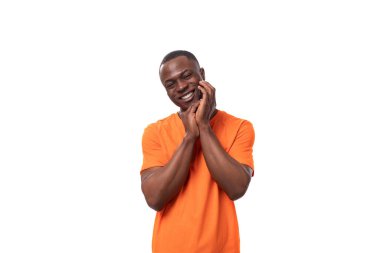 Turuncu tişört giymiş, beyaz arka planda fotokopi alanı olan ince bakımlı bir Afrikalı..