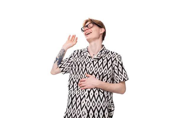 stock image young funny optimist man with red hair in glasses and a summer black and white shirt laughs out loud and feels pain in his stomach.