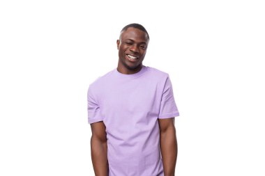 Eflatun tişörtlü gülümseyen Amerikalı genç bir adamın portresi beyaz arka planda, fotokopi alanı ile izole edilmiş..