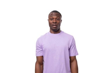 Beyaz arka planda, üzerinde fotokopi alanı olan pamuk tişört giymiş genç bir Amerikalı şaşırdı..