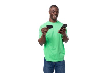 Nane tişörtü giymiş, elinde akıllı telefon ve kredi kartı olan genç bir Amerikalı..