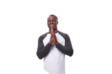 Yay ceketli genç, pozitif Afrikalı bir adam ellerini kavuşturdu ve en iyisini umdu..