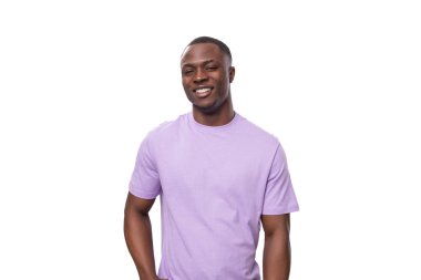 Beyaz arka planda açık leylak rengi tişört giymiş genç ve başarılı Amerikalı bir adam..