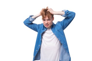 Mavi tişörtlü, beyaz tişörtlü, suratını buruşturan genç kızıl adam..