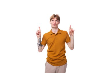 Sarı tişörtlü, kısa kızıl saçlı, genç, modaya uygun bir öğrenci aktif olarak el kol hareketi yapıyor..