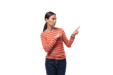 Dar turuncu kazak giymiş çekici, genç esmer kadın parmağını yana doğru gösteriyor..