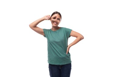 30 yaşındaki Avrupalı, at kuyruklu esmer kadın yeşil tişört ve kot pantolon giymiş ve arka planda fotokopi alanı var..