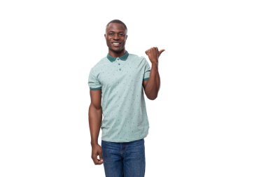 Genç, bakımlı, Afrikalı bir adam. Sıradan giyinmiş, elini yana uzatmış, yer açıyor..