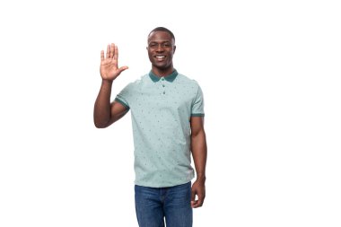 Genç, mutlu, pozitif, kısa saçlı, beyaz arka planda yaz tişörtü giymiş Amerikalı bir adam..