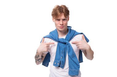 Kızıl saçlı ve kollarında stüdyo arka planında dövmesi olan düşünceli genç bir Avrupalı adamın portresi. insanlar yaşam tarzı konsepti.