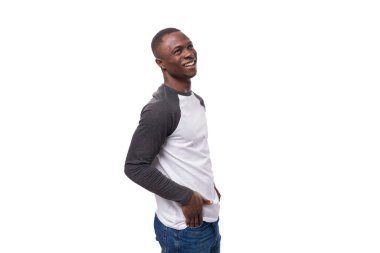 Genç, pozitif, gülümseyen, kısa saçlı, stüdyo arka planında sıradan bir ceket giyen Amerikalı adam..