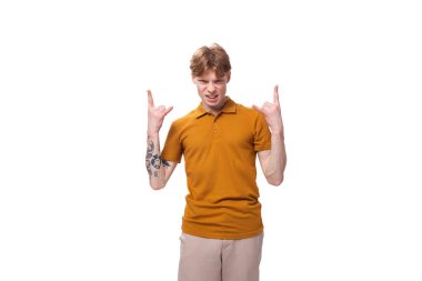 Sarı tişörtlü, kısa kızıl saçlı, genç, modaya uygun bir öğrenci aktif olarak el kol hareketi yapıyor..