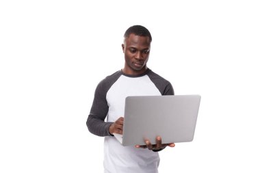 Uzaktan kumandalı bilgi işlem alanında çalışan ve dizüstü bilgisayar kullanan genç bir Afrikalı..