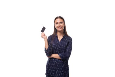 Koyu mavi bluz giymiş, beyaz tenli, genç ve hoş bir bayan. Elinde bir kredi kartı var..