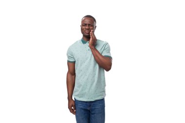 Kısa saçlı, naneli tişört ve kot pantolon giyen yakışıklı Afrikalı adam..