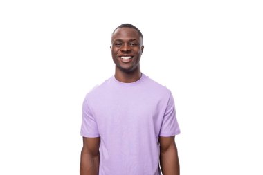 Beyaz arka planda gülümseyen leylak tişörtlü genç pozitif Amerikalı adam..