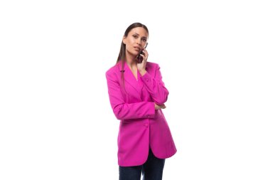 Genç, bakımlı, esmer, başarılı, pembe ceketli kadın telefonda konuşuyor..