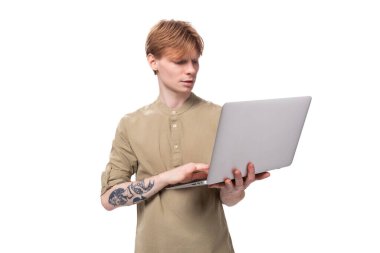 Kızıl saçlı beyaz bir çocuk uzaktan bilgisayarla çalışıyor..