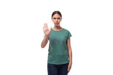 Yeşil tişört ve kot giyen güzel esmer bayan, jestlerle dikkat çekiyor..