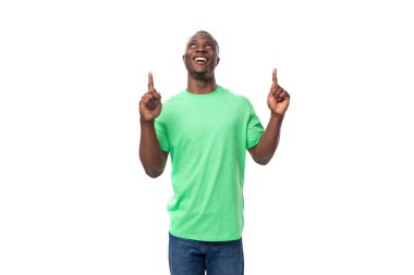 Sıradan tişörtlü genç pozitif Amerikalı adam beyaz arka planda seviniyor..