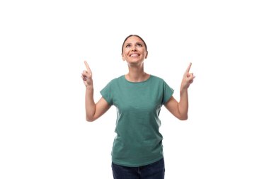 Yeşil tişört ve kot pantolon giymiş, bakımlı, esmer bir kadının portresi..