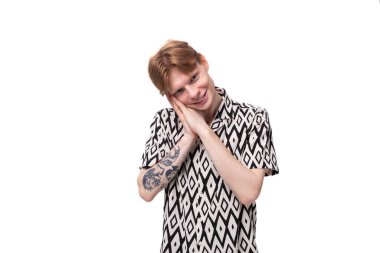 Genç, kızıl saçlı, beyaz, kısa kollu, yaz gömlekli adam üzgün..