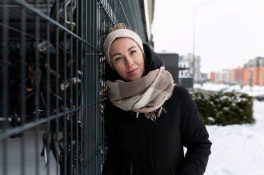 Sarışın bir kadın kışın şehirde yürüyor..