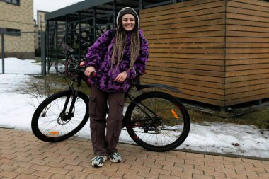 Atletik genç kadın soğuk mevsimde bisiklet sürmeyi sever..