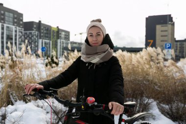 Kışın bisiklet süren sevimli genç bir kadın..