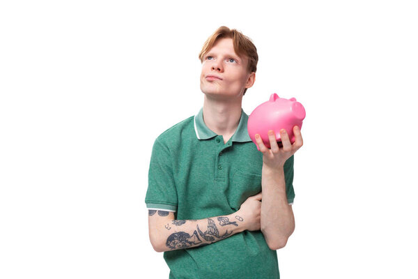 a young man with red hair dressed in a green T-shirt dreams of where to spend his savings.
