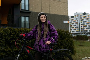 Evin yanında bisikletiyle duran hoş bir genç bayan..