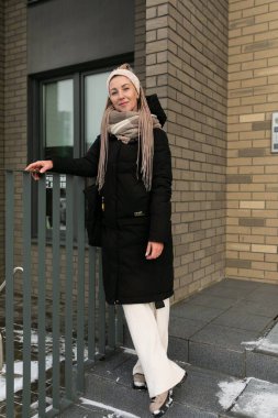 Siyah kışlık ceket giyen, sarışın, güzel bir kadın..