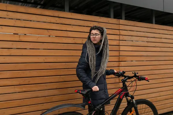 Sarışın, çekici bir kadın soğuk mevsimde bisiklet sürüyor..