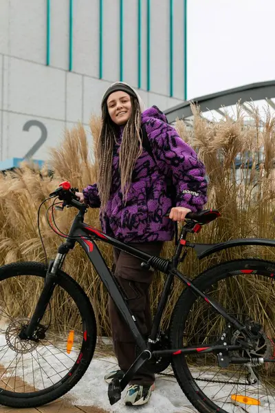 Piercingli ve rastalı hoş genç bir kadın şehirde bisiklet kiralamış..