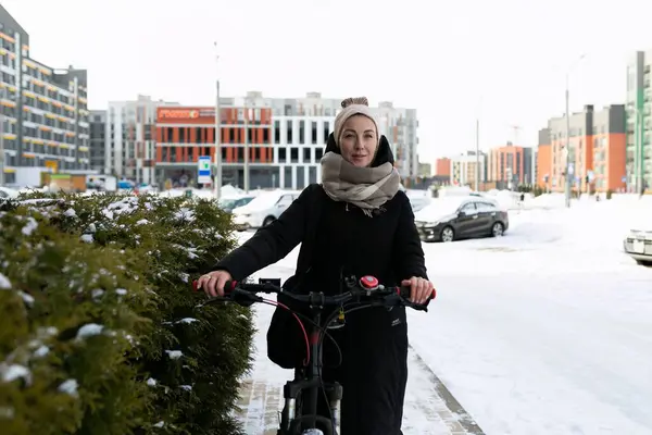 Sarışın, sırıtan sevimli bir kadın kışın bisiklet kiraladı..