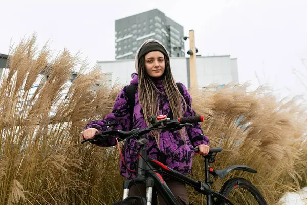 Piercingli ve rastalı hoş genç bir kadın şehirde bisiklet kiralamış..