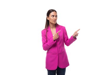 Parlak ahududu ceketi giymiş beyaz tenli bir iş kadını sohbette el kol hareketi yapar..