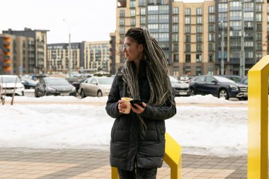 Yaşam tarzı konsepti, saçları örgülü genç Avrupalı bir kadın şehirde dolaşıyor..