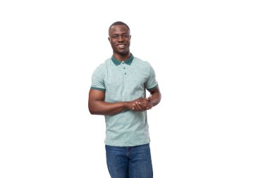 Genç, pozitif, kısa saçlı Amerikalı bir adamın portresi. Nane yeşili bir yaz tişörtü giymiş, beyaz bir arka planda..